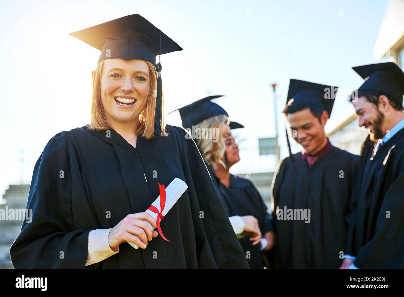 It pays to put in the effort. Portrait of a student holding her diploma on graduation day. Stock Photo