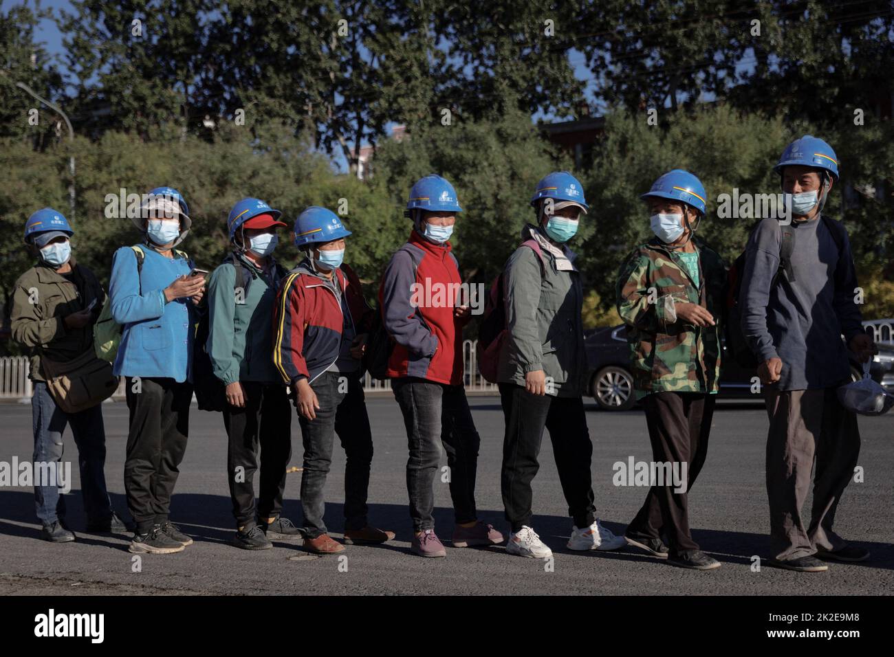 Workers line up to enter the construction site of the new Workers' Stadium in Beijing, China, September 23, 2022. REUTERS/Thomas Peter Stock Photo