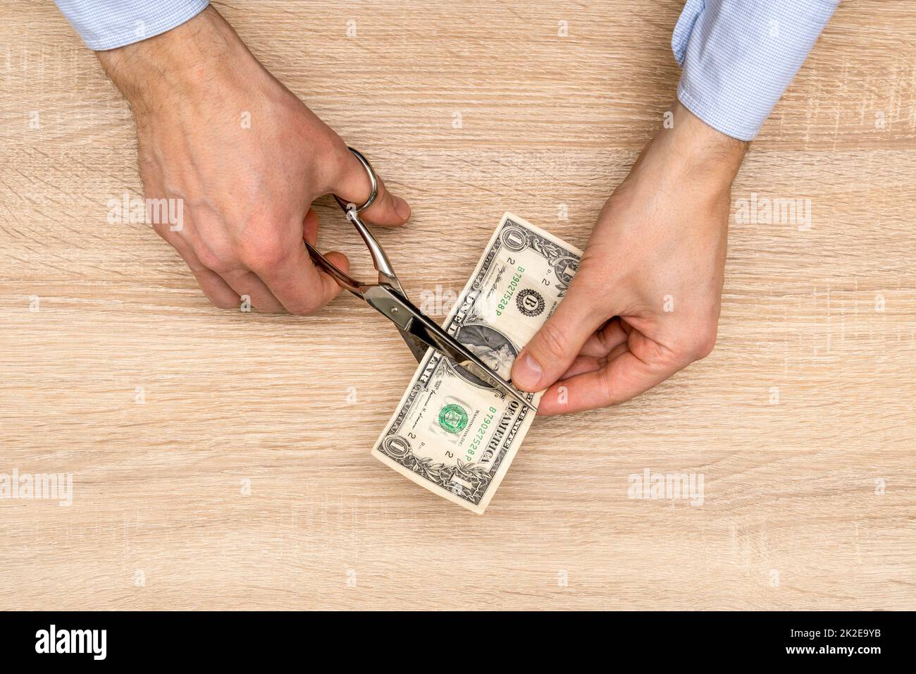 Hands with scissors cutting money Stock Photo