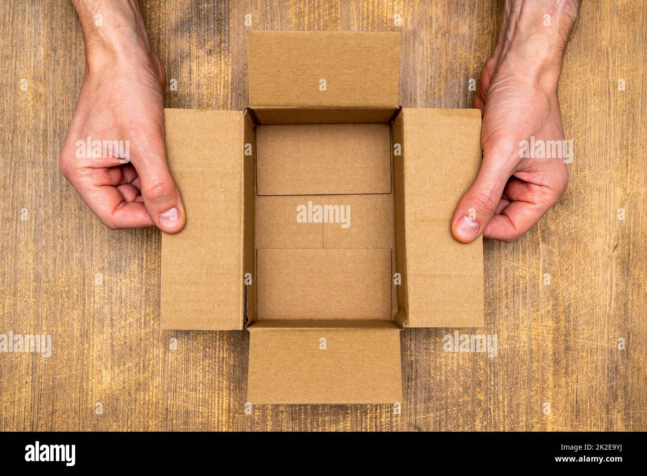 Hands opening empty brown cardboard box Stock Photo Alamy