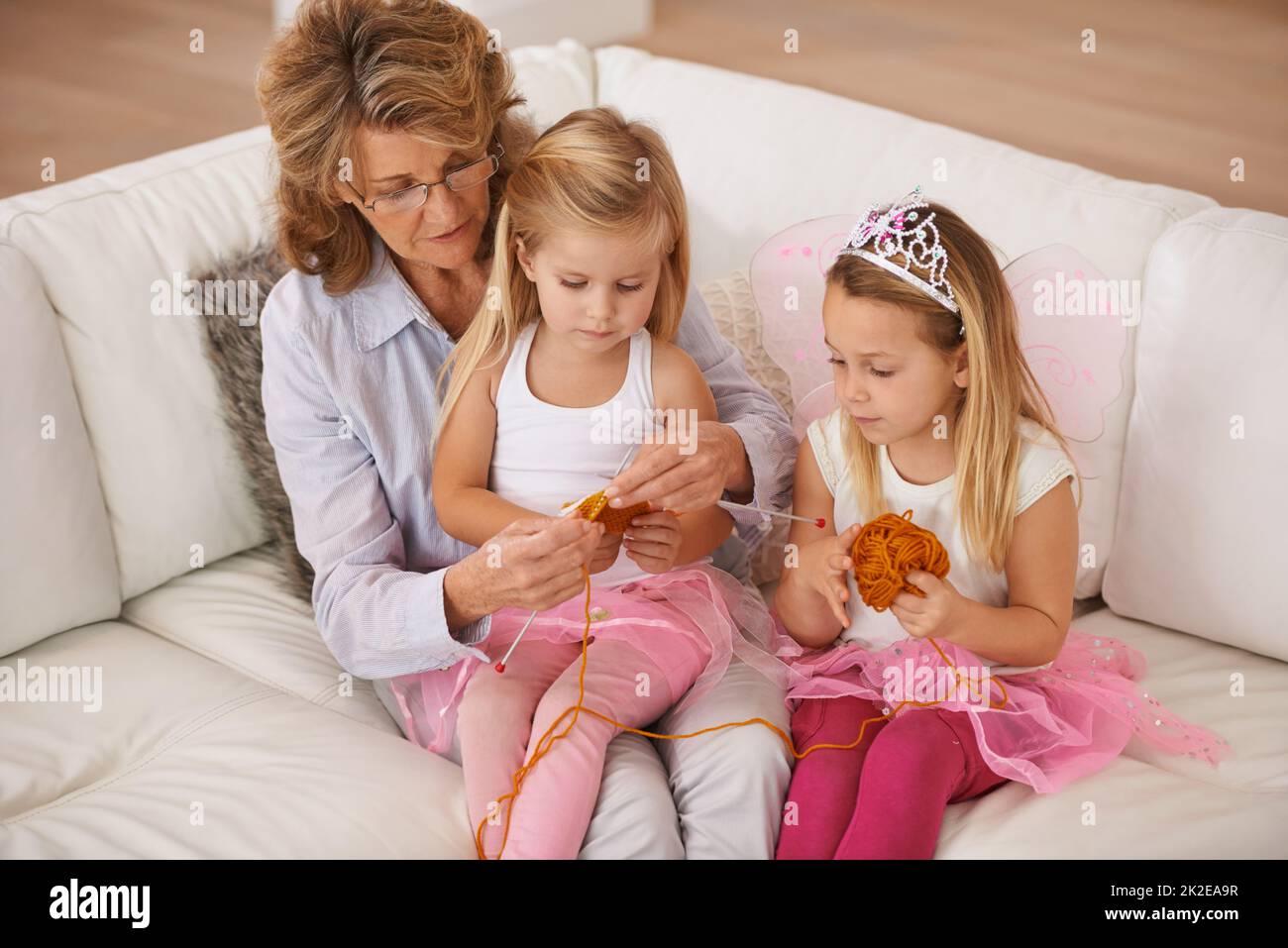 Grannys showing us how to knit. A grandmother spending time with her granddaughter. Stock Photo