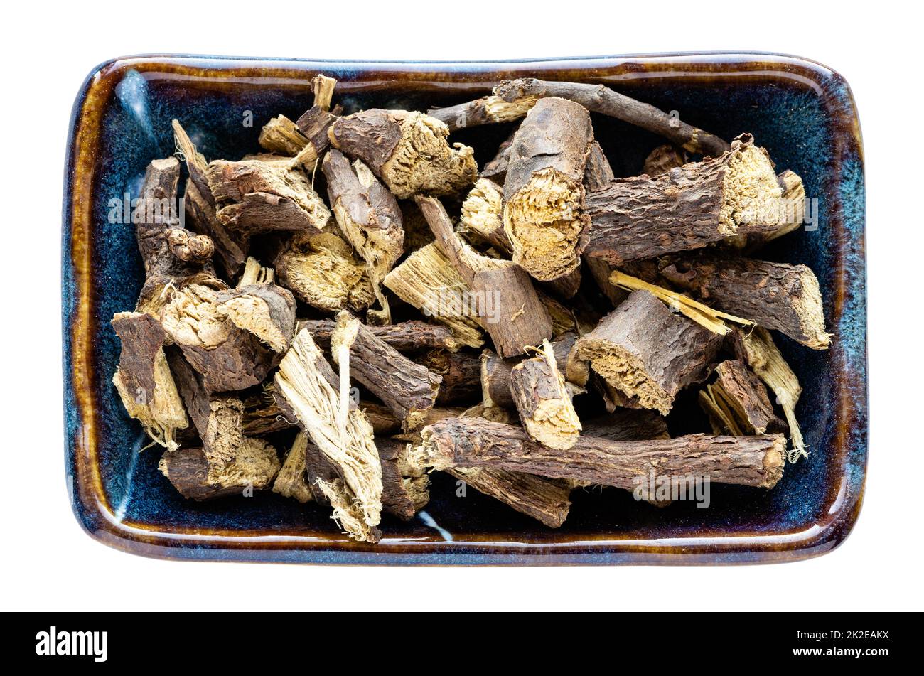 dried Liquorice roots in bowl isolated on white Stock Photo