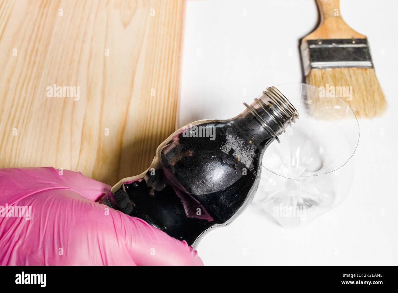 pouring wood stain from plastic bottle into jar Stock Photo Alamy