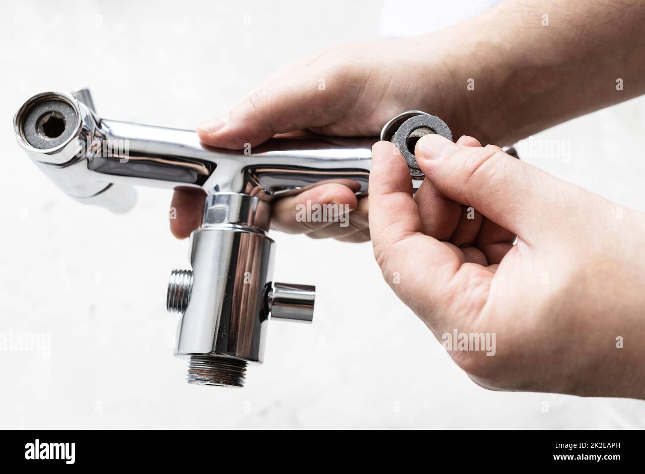 plumber installs paronite gasket in faucet closeup Stock Photo
