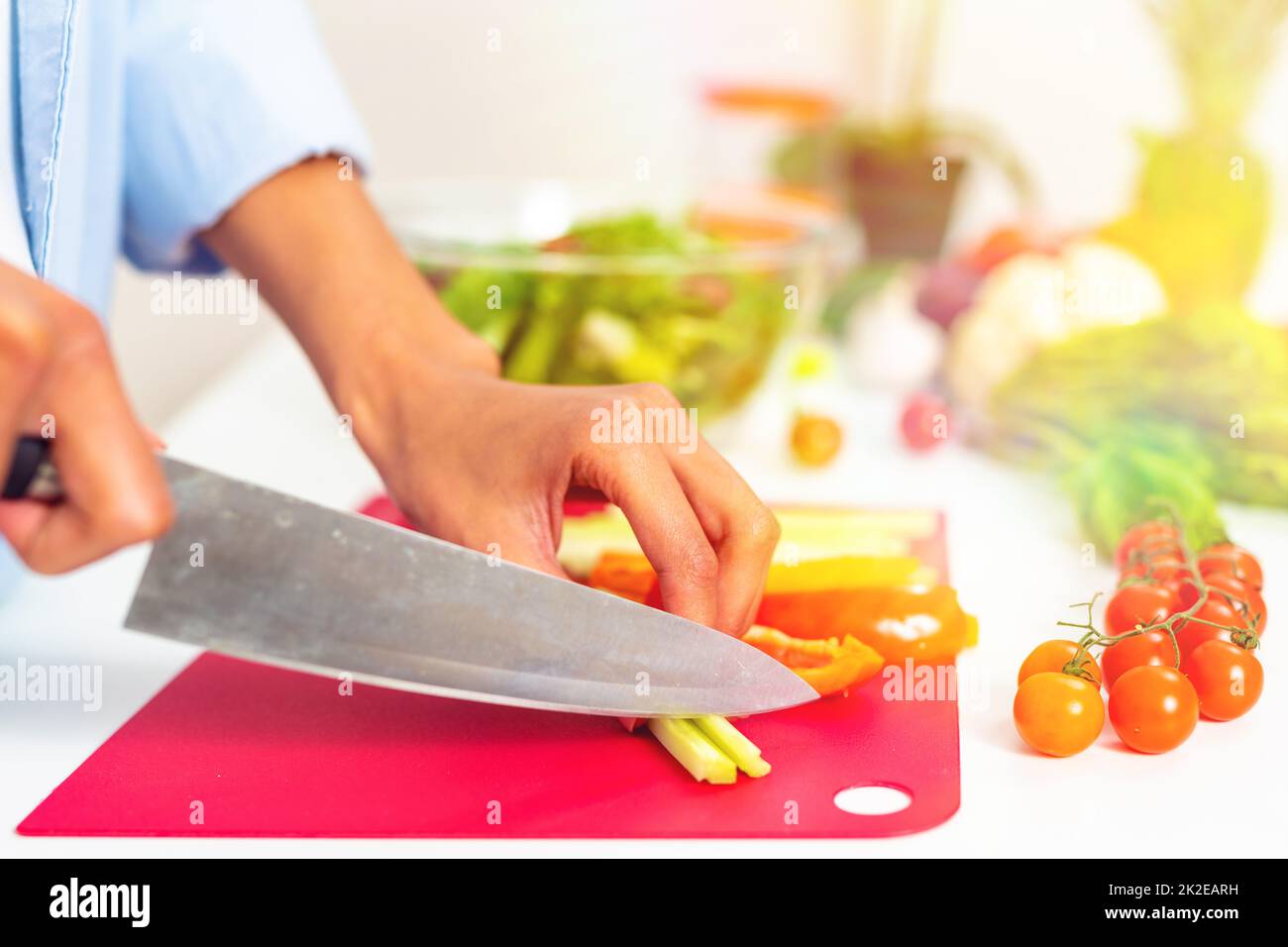 Woman in the home kitchen prepares a genuine salad with fresh vegetables Stock Photo