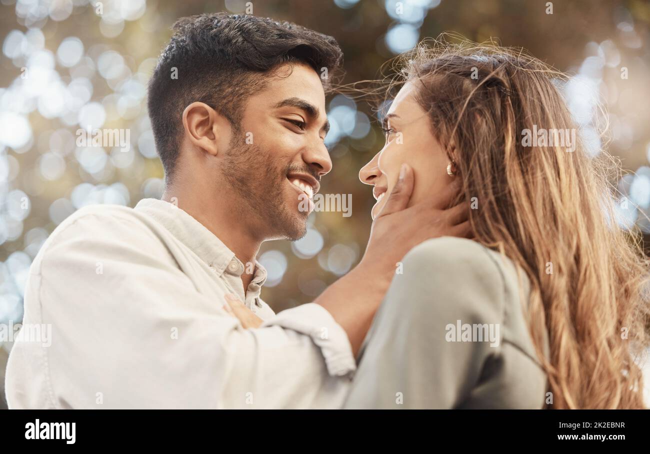 Happy couple, love and commitment while outside at a park sharing a romantic moment and looking into eyes with a smile. Safe, secure and happy man and Stock Photo