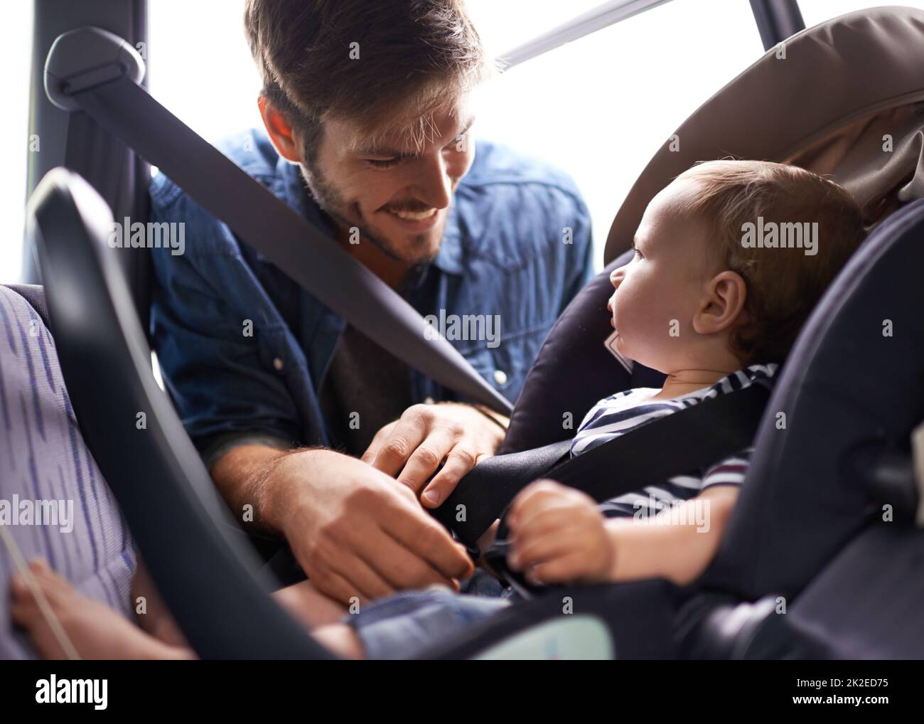 Safety first. A young father strapping his baby into a car seat Stock