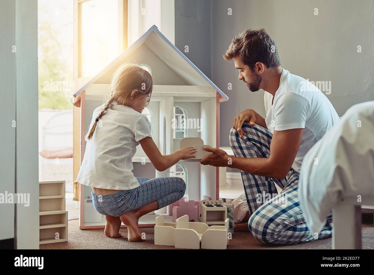 Invest the time to win her heart. Shot of an adorable little girl spending time with her father at home. Stock Photo