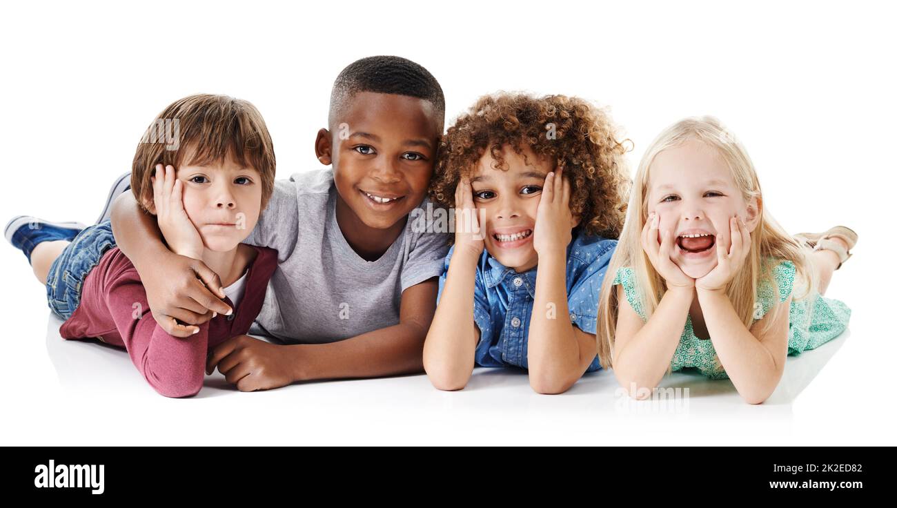 Friends have the most fun. Studio shot of a group of young friends lying on the floor together against a white background. Stock Photo