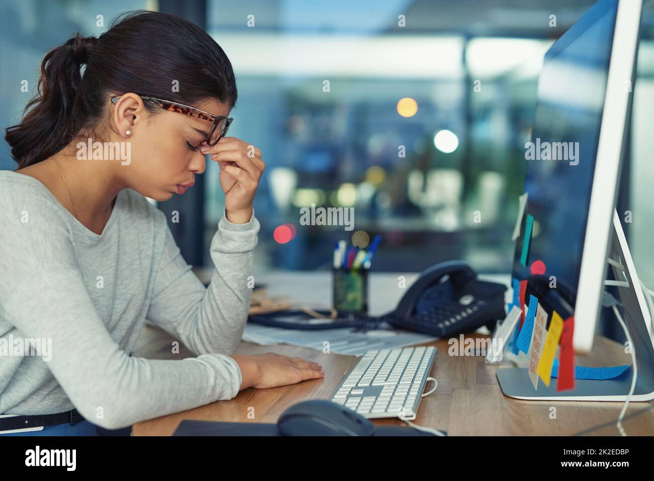 This pain is completely unbearable. Shot of a young businesswoman looking stressed out in an office. Stock Photo