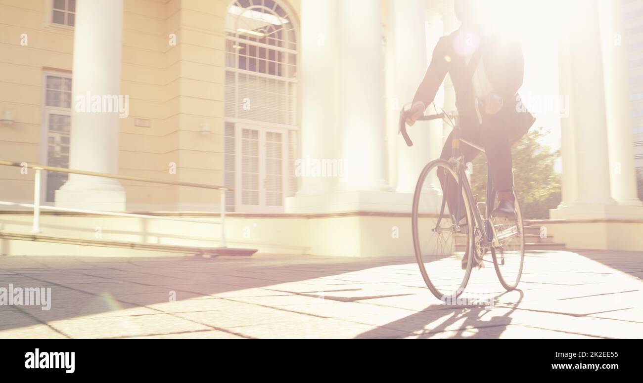 Everyone takes a different journey in life. Shot of an unrecognizable businessman commuting to work with his bicycle. Stock Photo