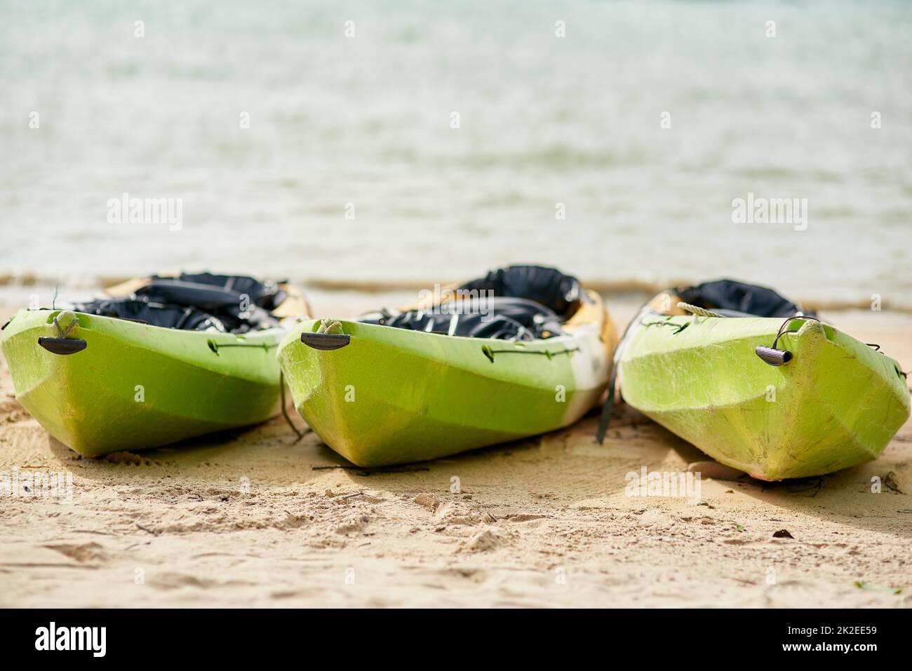 Ready to ride the waves. Still life shot of three canoes on the shore of the beach. Stock Photo