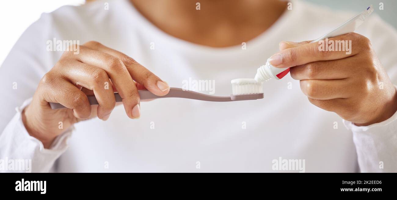 Dentistry is not expensive..neglect is. Shot of a unrecognizable young woman brushing her teeth in the morning. Stock Photo