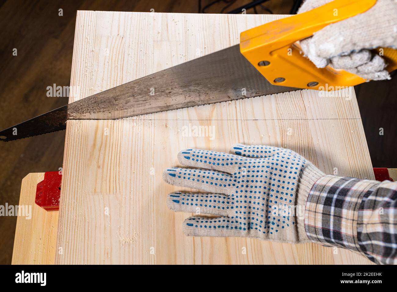above view of carpenter hands sawing wooden board Stock Photo