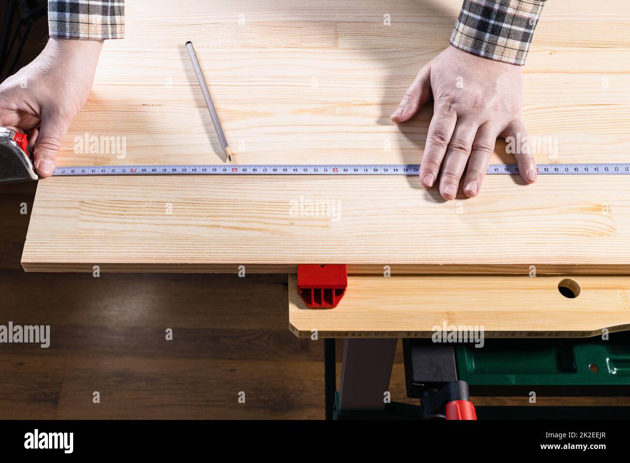 hands of carpenter measure size on wooden board Stock Photo