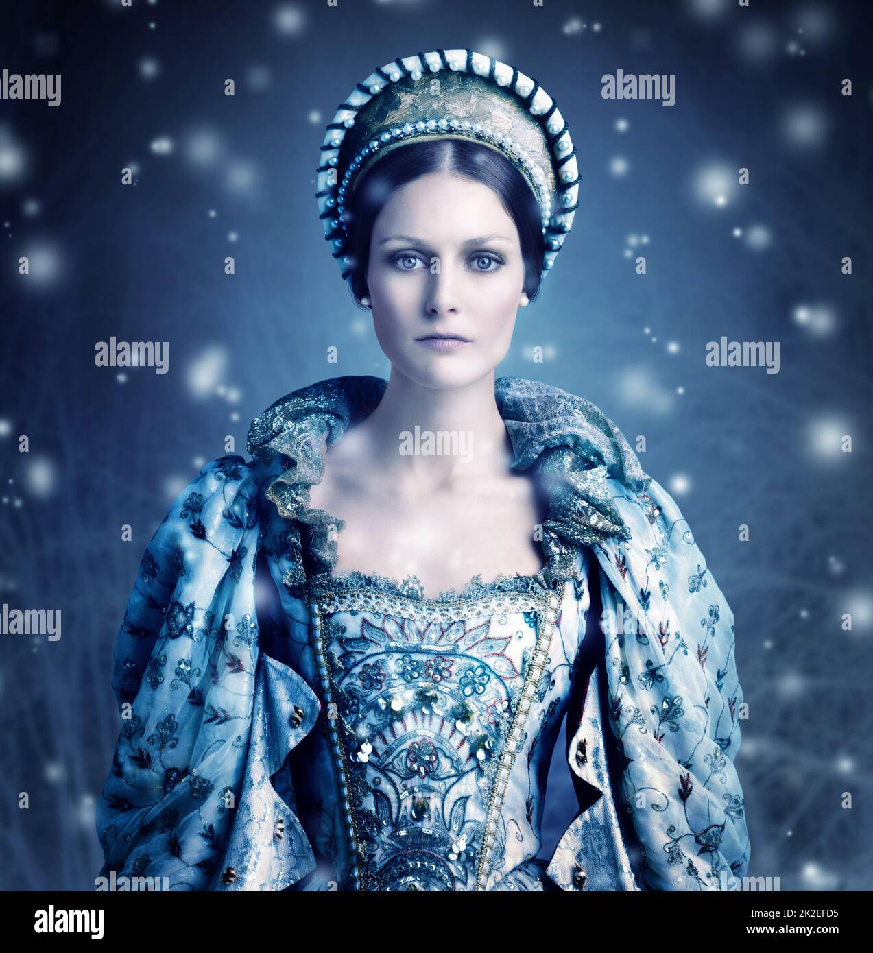 Here comes winter. Portrait of a evil-looking queen with snow falling around her. Stock Photo