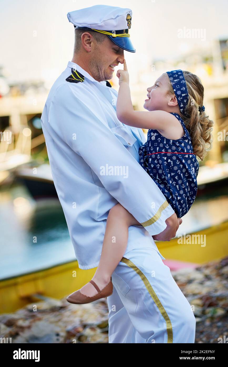 Got your nose. Shot of a father in a navy uniform bonding with his little girl on the dock. Stock Photo