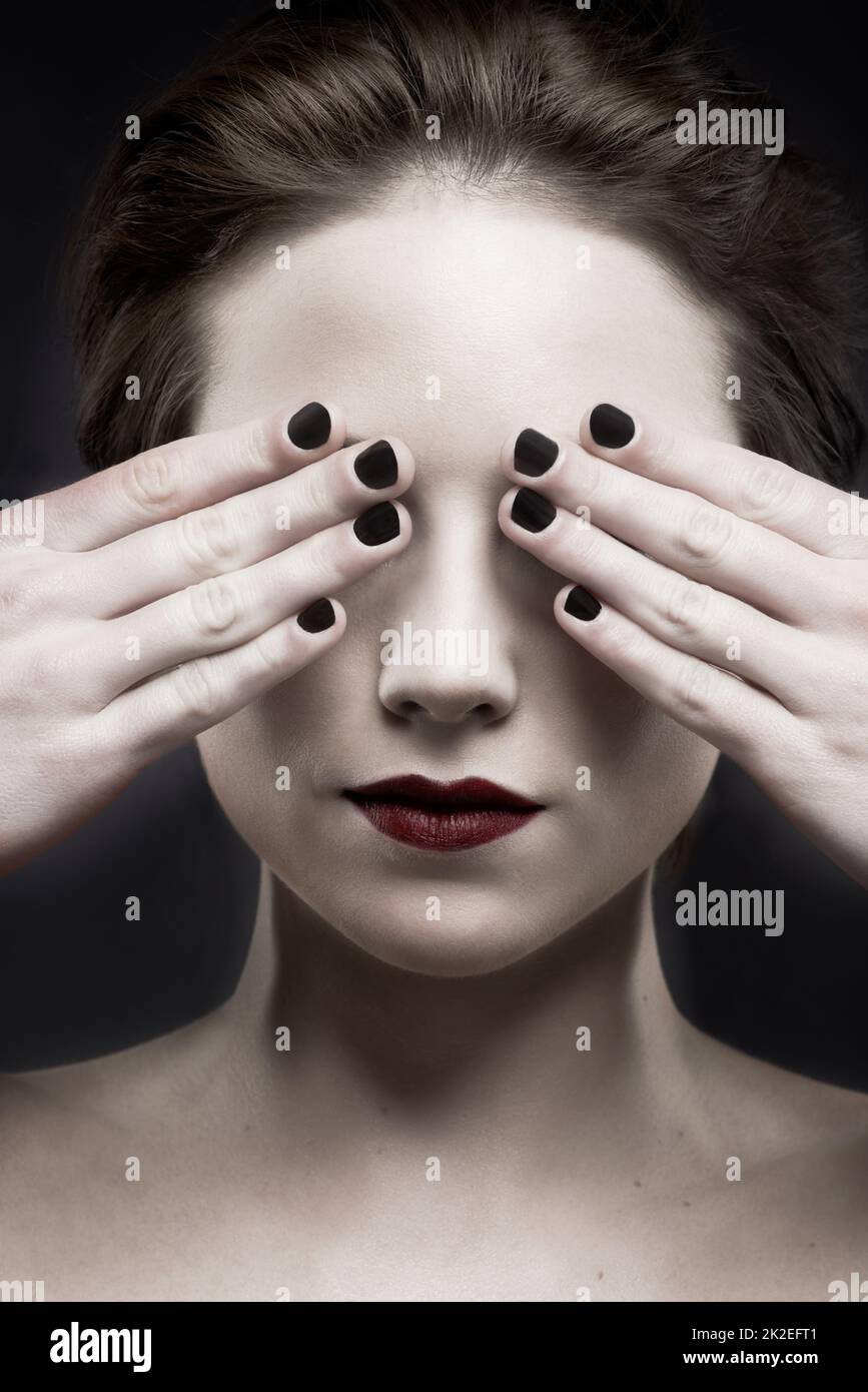See no evil. A beautiful pale woman with dark lipstick covering her