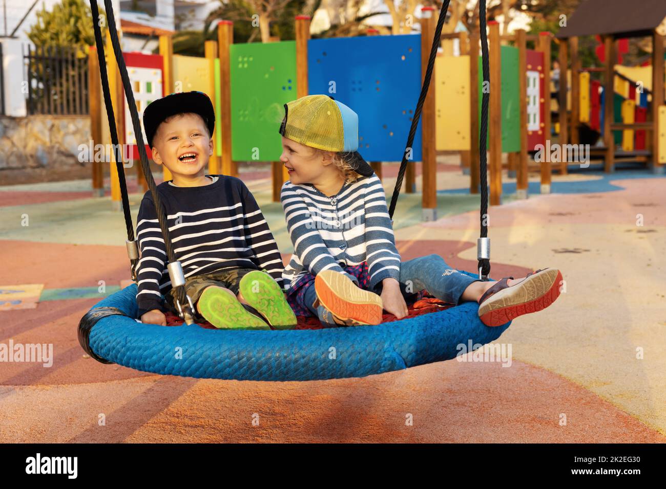 cheerful children having fun in playground basket swing Stock Photo