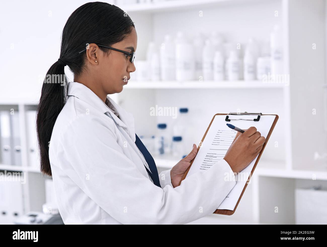 Filling out some important information. Cropped shot of an attractive young female scientist working on a clipboard in her laboratory. Stock Photo