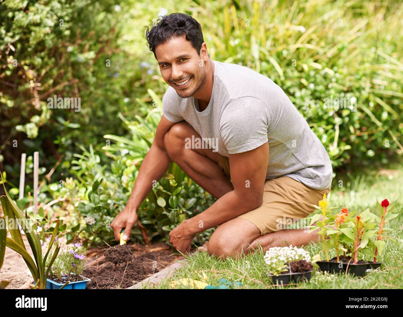 Gardening is so relaxing and rewarding. Portrait of a handsome young man working in his garden. Stock Photo