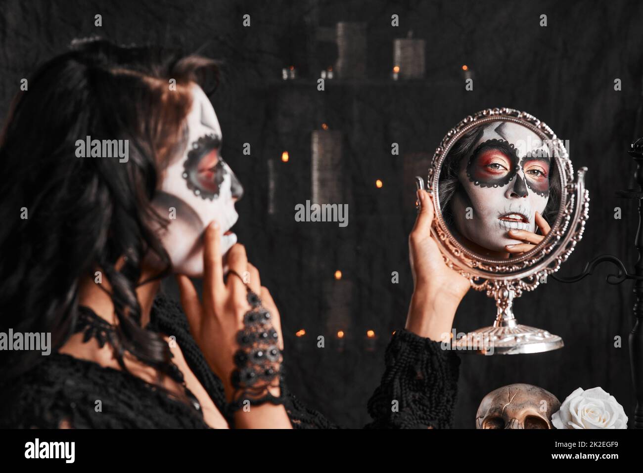 Halloween makeup on point. Cropped shot of an attractive young woman dressed in her Mexican-style halloween costume looking in a mirror. Stock Photo