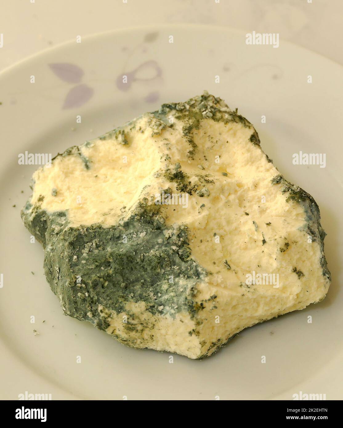 The harms of consuming green moldy cheese Stock Photo