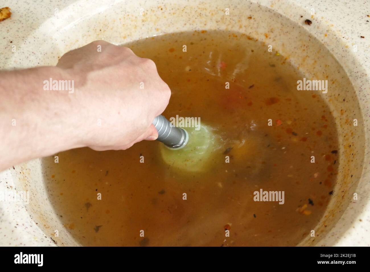 using a plastic kitchen pump to unclog the kitchen sink Stock Photo Alamy