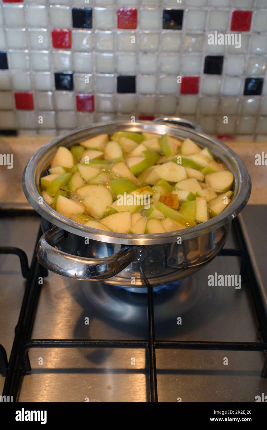 making apple compote,chopped apple pieces boiling in a pot,making