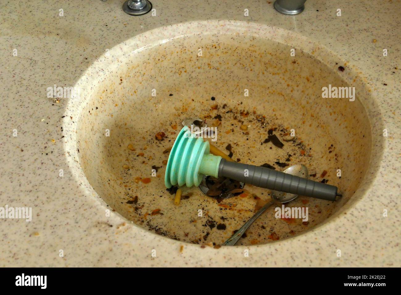 using a plastic kitchen pump to unclog the kitchen sink Stock Photo Alamy