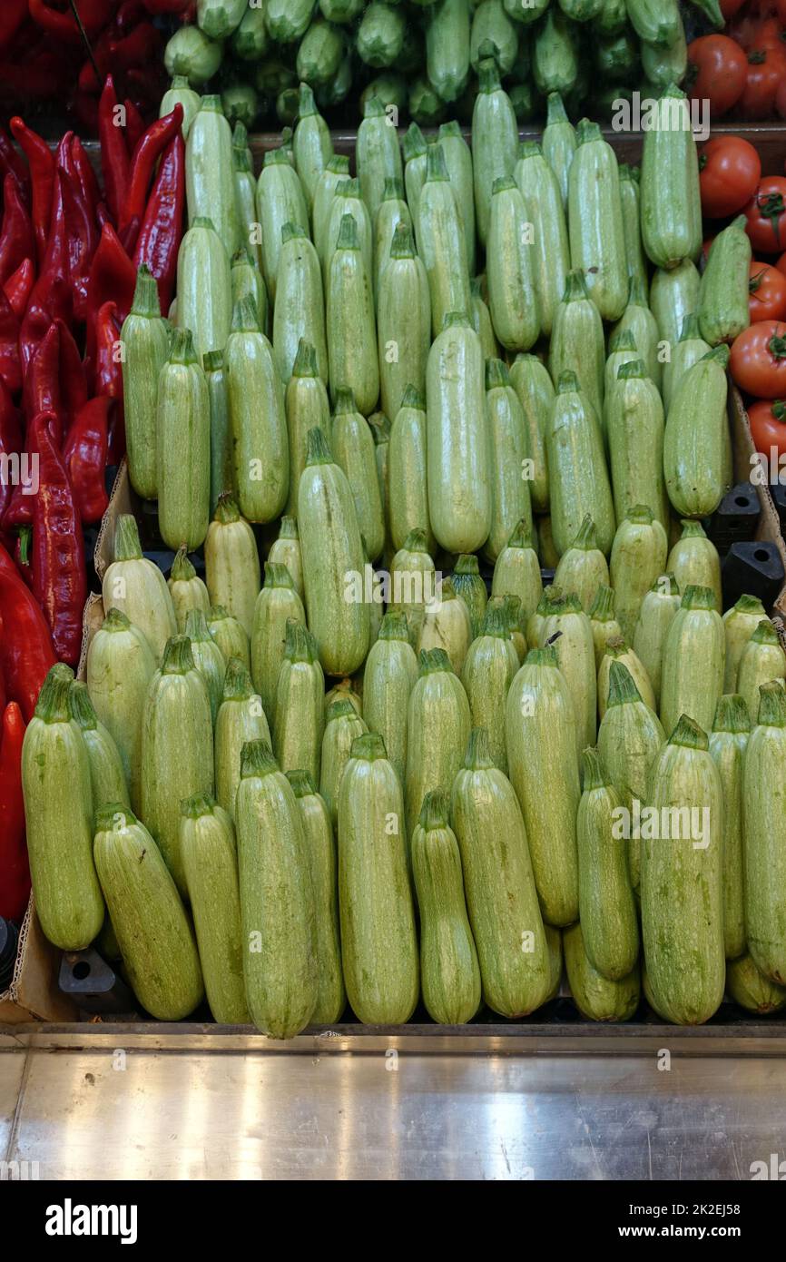 fresh zucchini in the greengrocer aisle, zucchini lined up for sale in large quantities Stock Photo