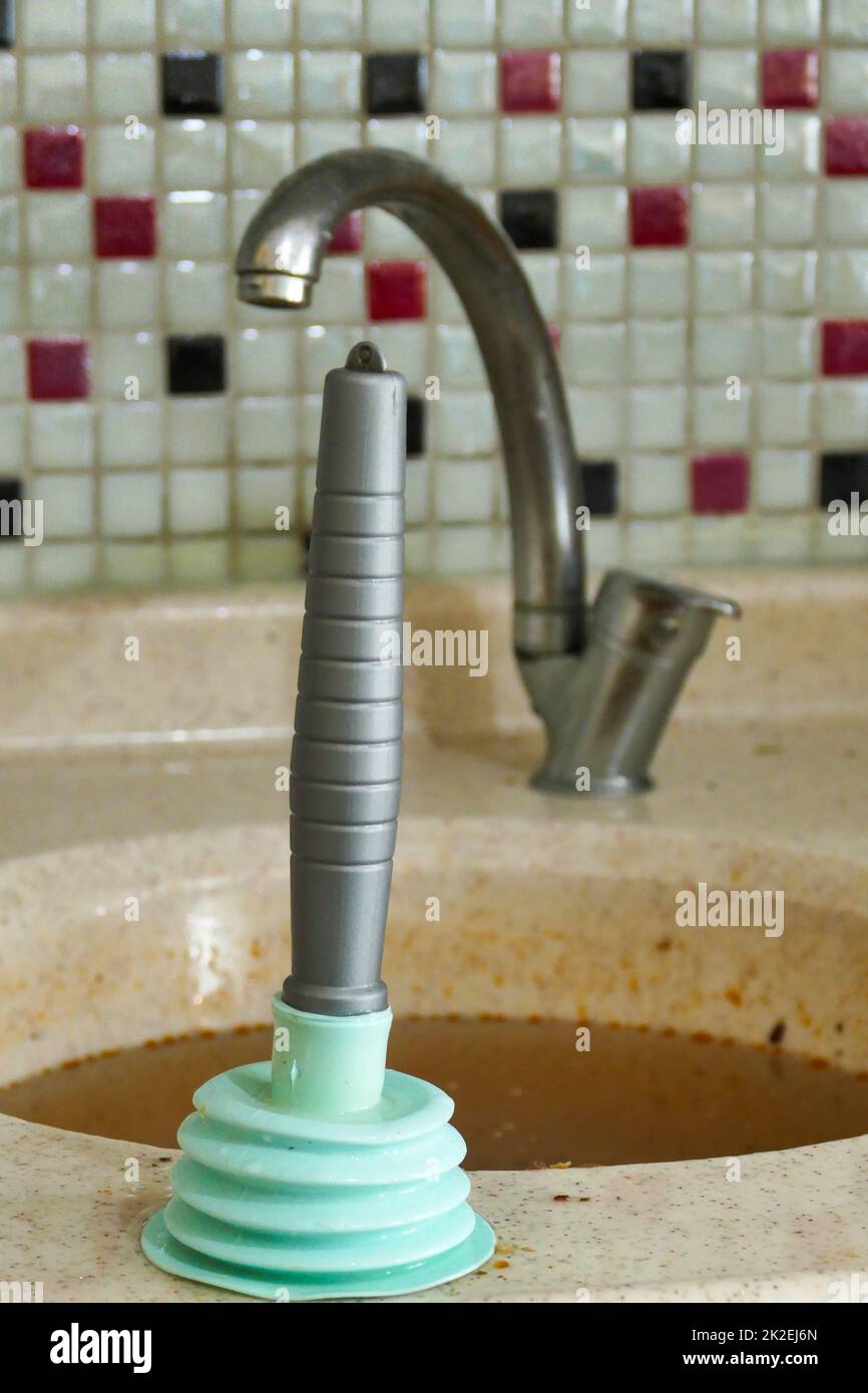 using a plastic kitchen pump to unclog the kitchen sink Stock Photo Alamy