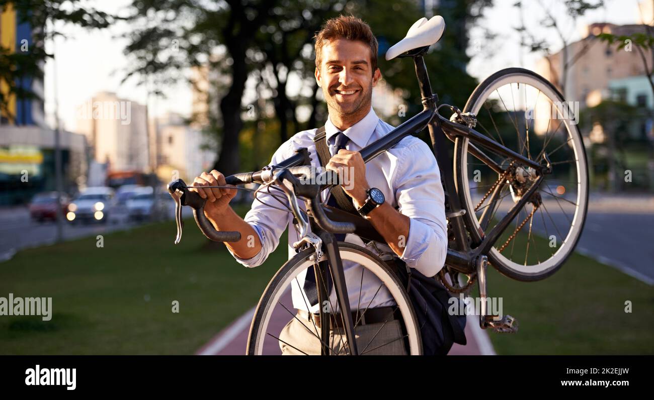 Just think how much petrol youre saving. Shot of a businessman commuting to work with his bicycle. Stock Photo