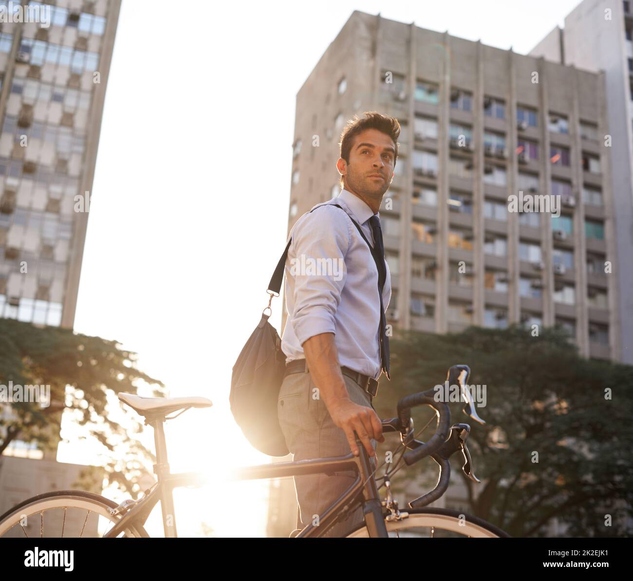 Serious about his carbon footprint as low as possible. Shot of a businessman commuting to work with his bicycle. Stock Photo