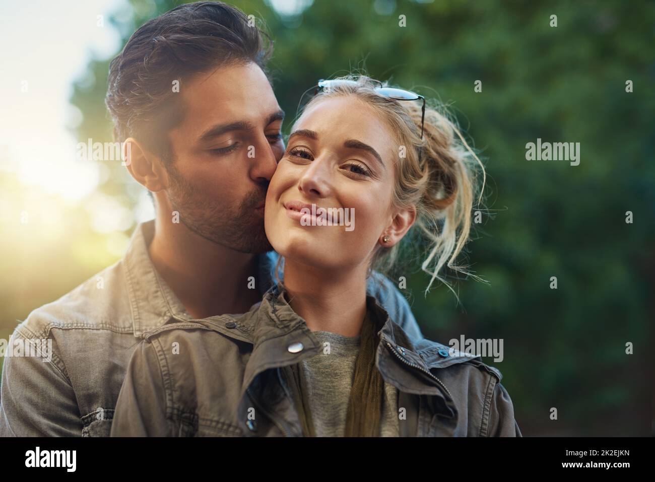 I love being his. Shot of a young couple out in the city. Stock Photo