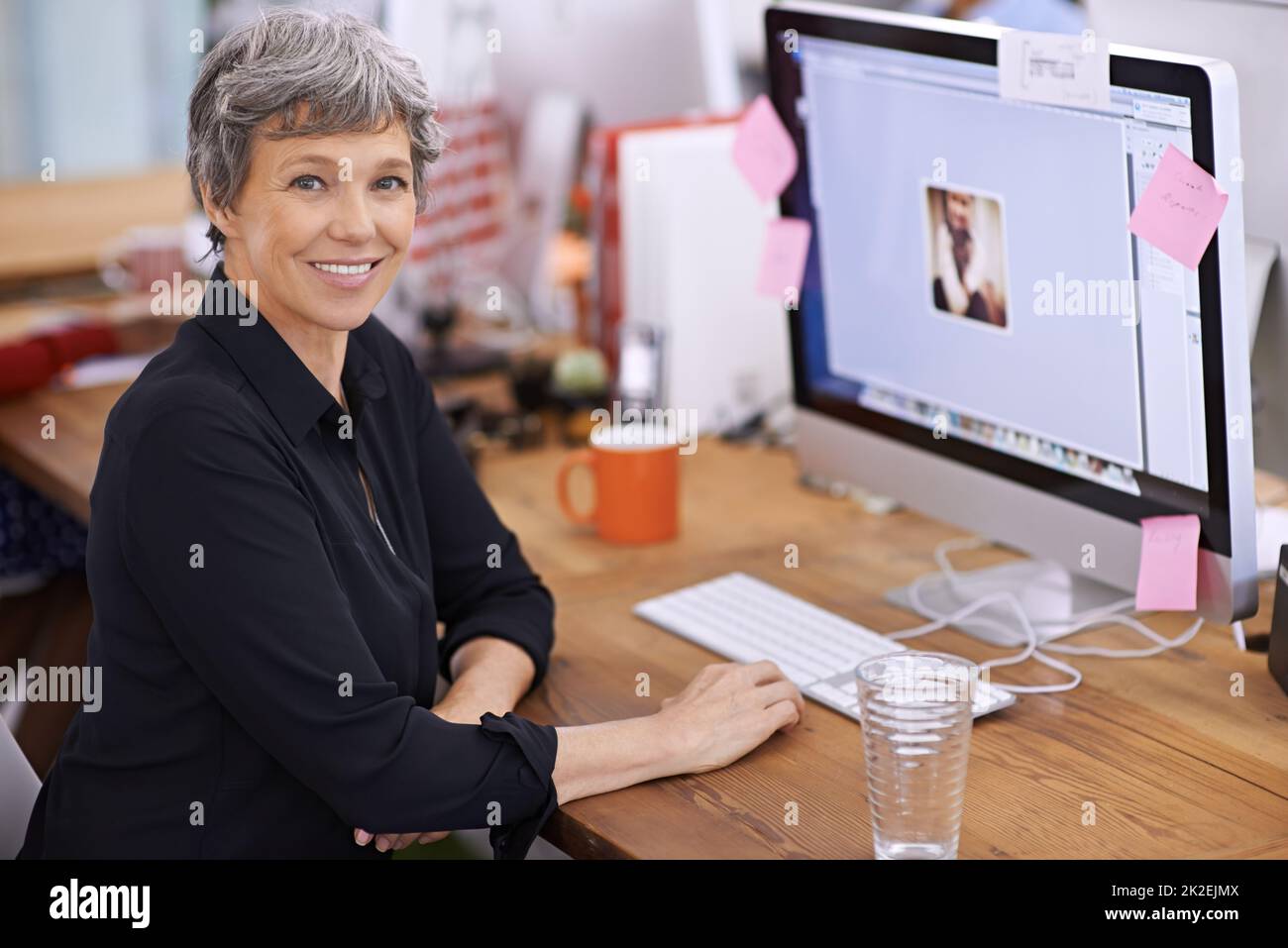 Mature woman in office smiling hi-res stock photography and images - Alamy