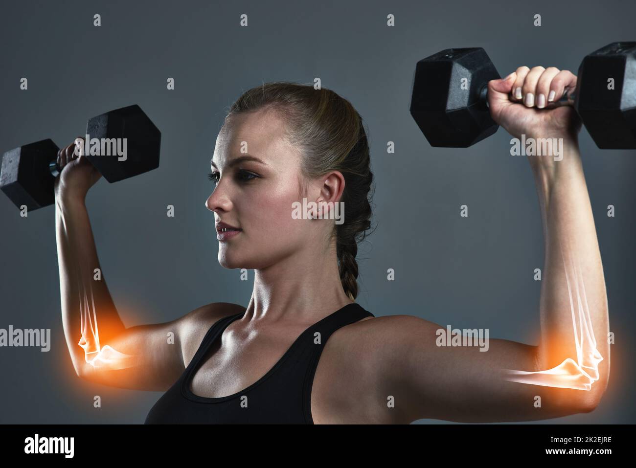 Its working right where I want it. Studio shot of a sporty young woman building muscle in her arms. Stock Photo