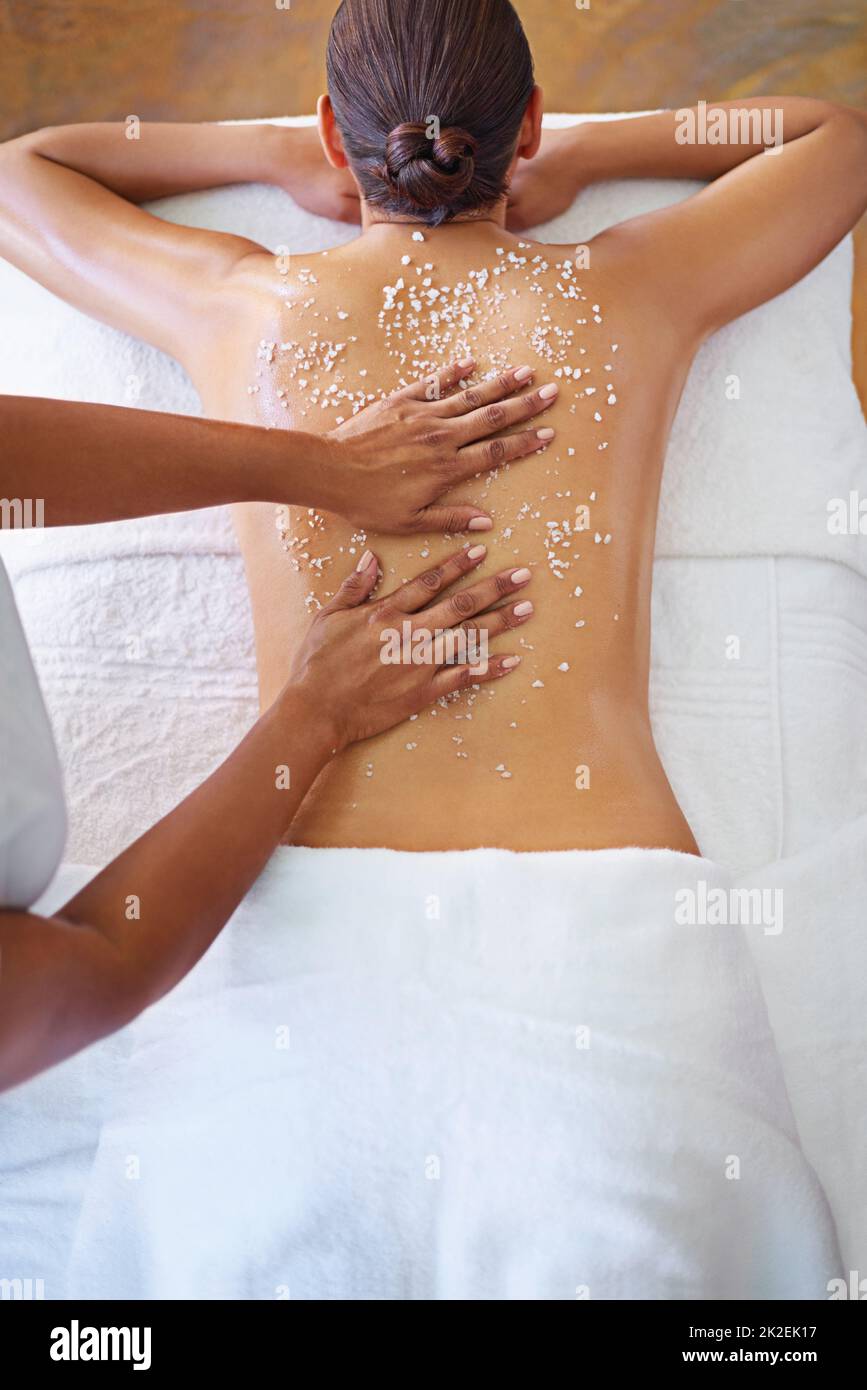 On her way to smooth, silky skin. Rearview shot of a woman getting an exfoliation treatment. Stock Photo