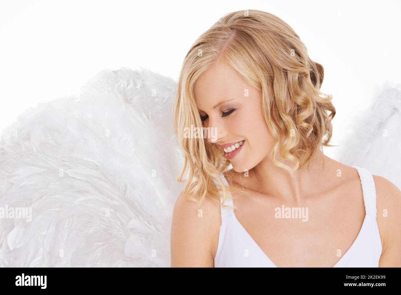 Her beauty is luminous. Studio shot of a young woman in angel wings isolated on white. Stock Photo