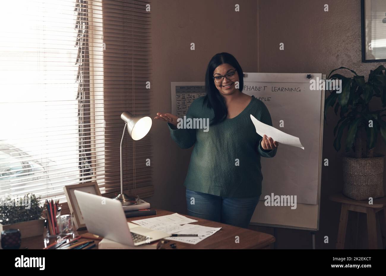 Dedicated to her students even at a distance. Shot of a young woman using a laptop to teach a lesson from home. Stock Photo