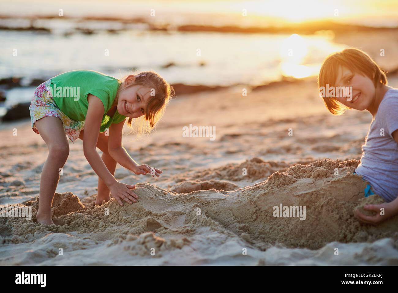 Were going to build the biggest sandcastle ever. Portrait of two young siblings playing together in the sand at the beach. Stock Photo