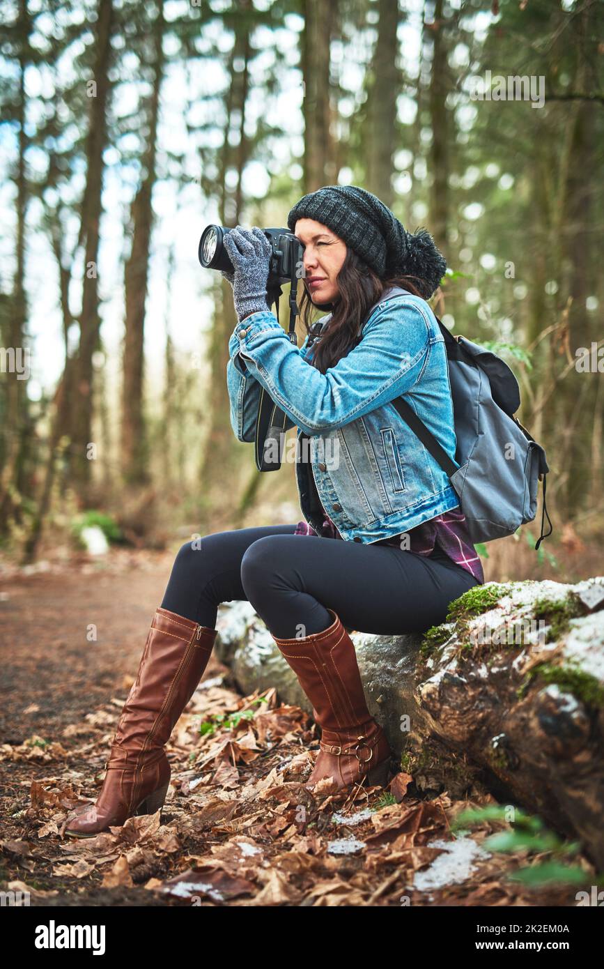 I have to take photos while Im travelling. Shot of a young woman taking a picture in the outdoors. Stock Photo