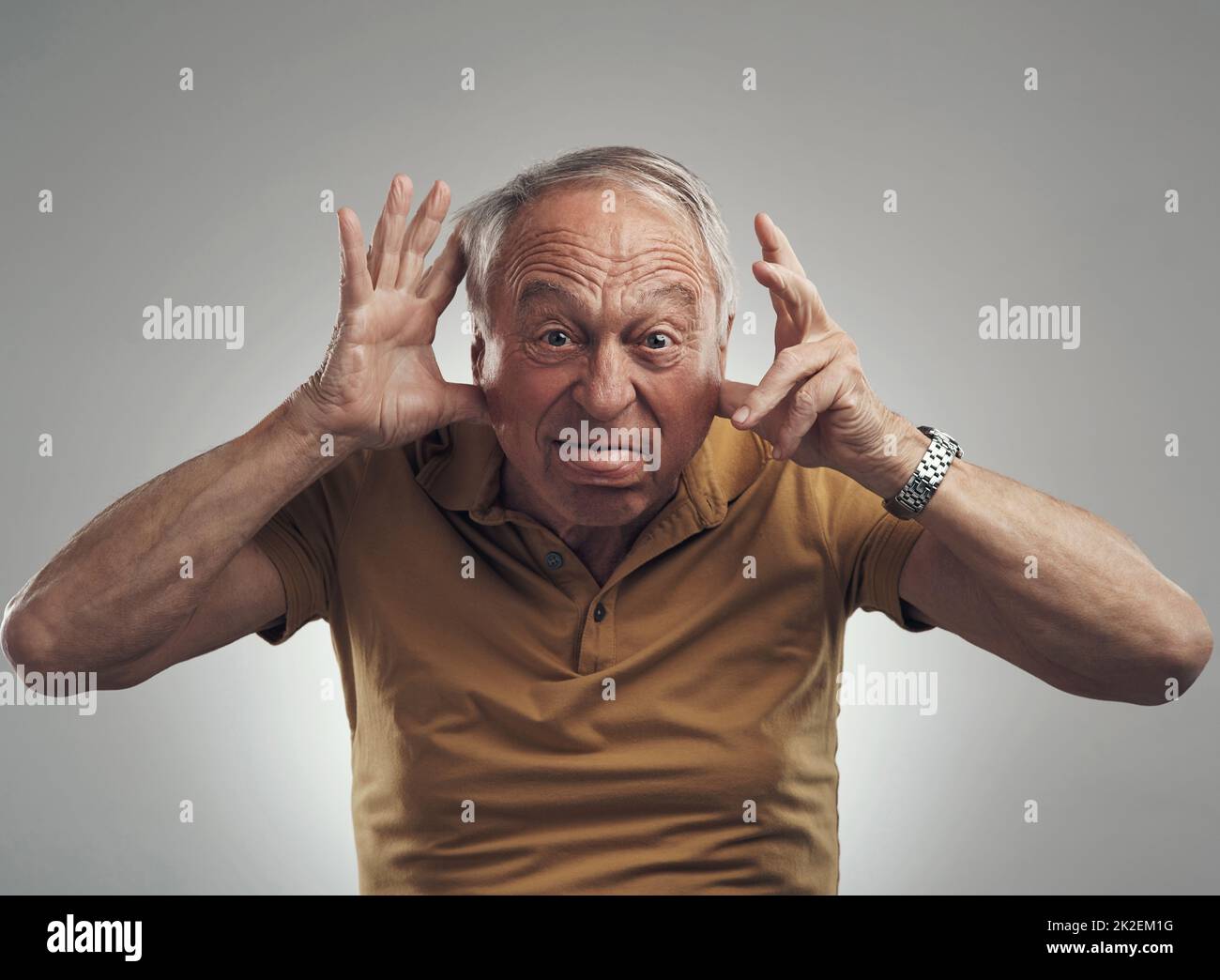 Int ouch with my inner child. Studio shot of an elderly man making a funny face against a grey background. Stock Photo