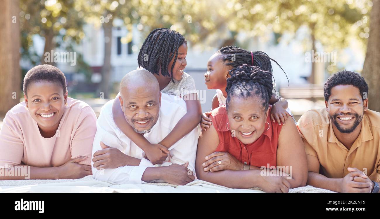 Nature, garden and portrait of a happy black family relaxing together while on summer vacation. Smile, park and positive african people on a picnic Stock Photo