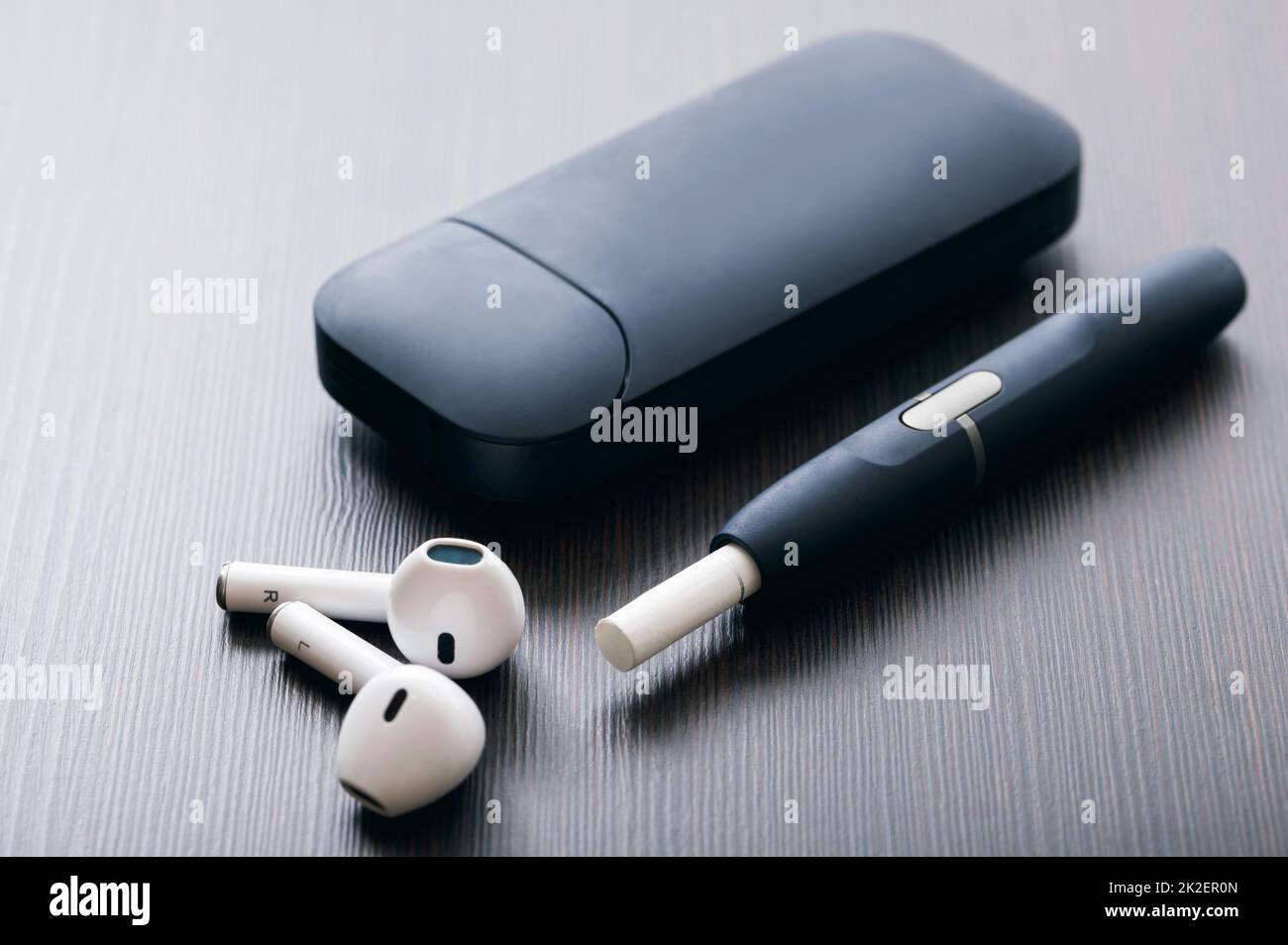 Tobacco heating system and white wireless earphones Stock Photo