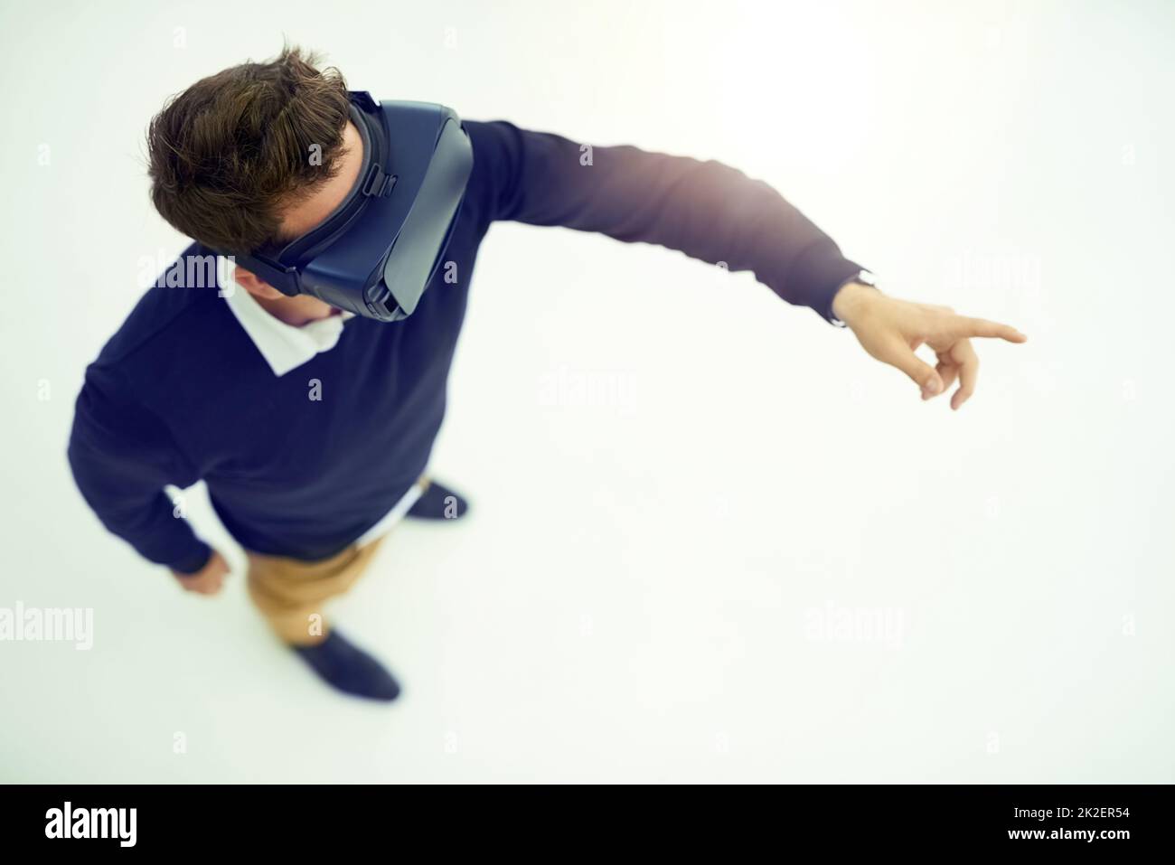 Logged in to the virtual world. High angle shot of a businessman wearing a VR headset while connecting to a user interface in an office. Stock Photo