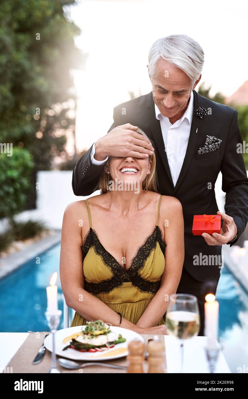 Keep your eyes closed for the surprise. Shot of a mature couple out on a romantic date. Stock Photo