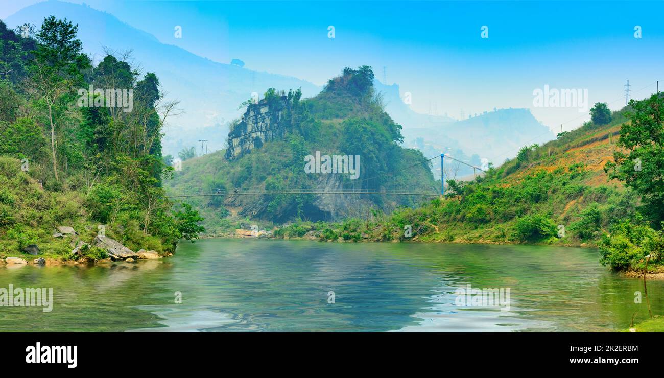 image of a suspension bridge over a small river in Tua Chua district, Dien Bien province, Vietnam Stock Photo