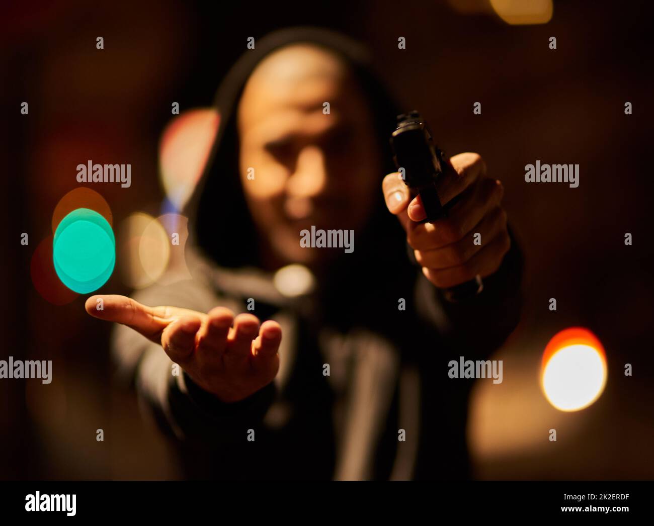 Your goods or your life. Shot of a gun-wielding thief aiming his weapon. Stock Photo