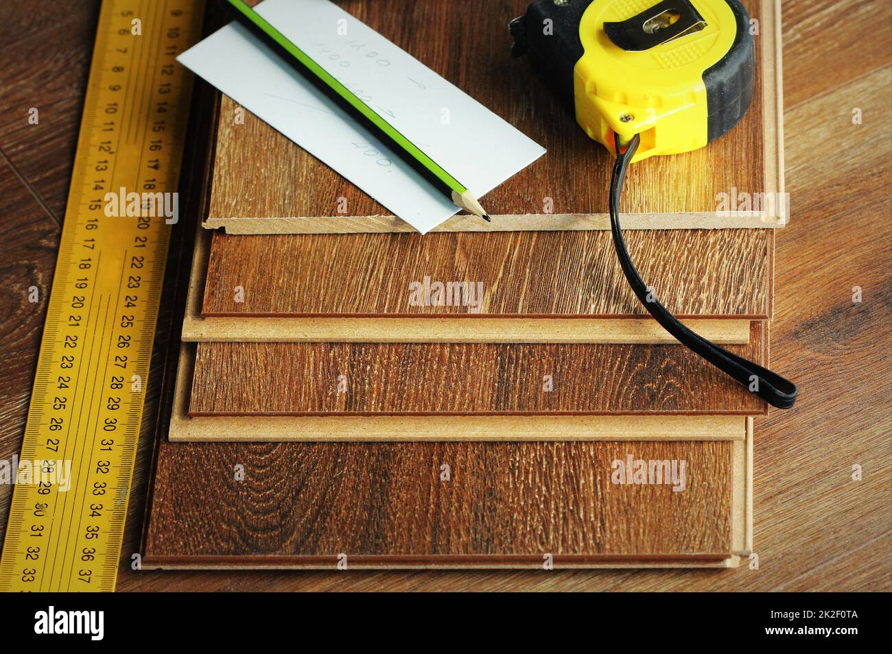 Laminate floor planks and tools on wooden background Stock Photo